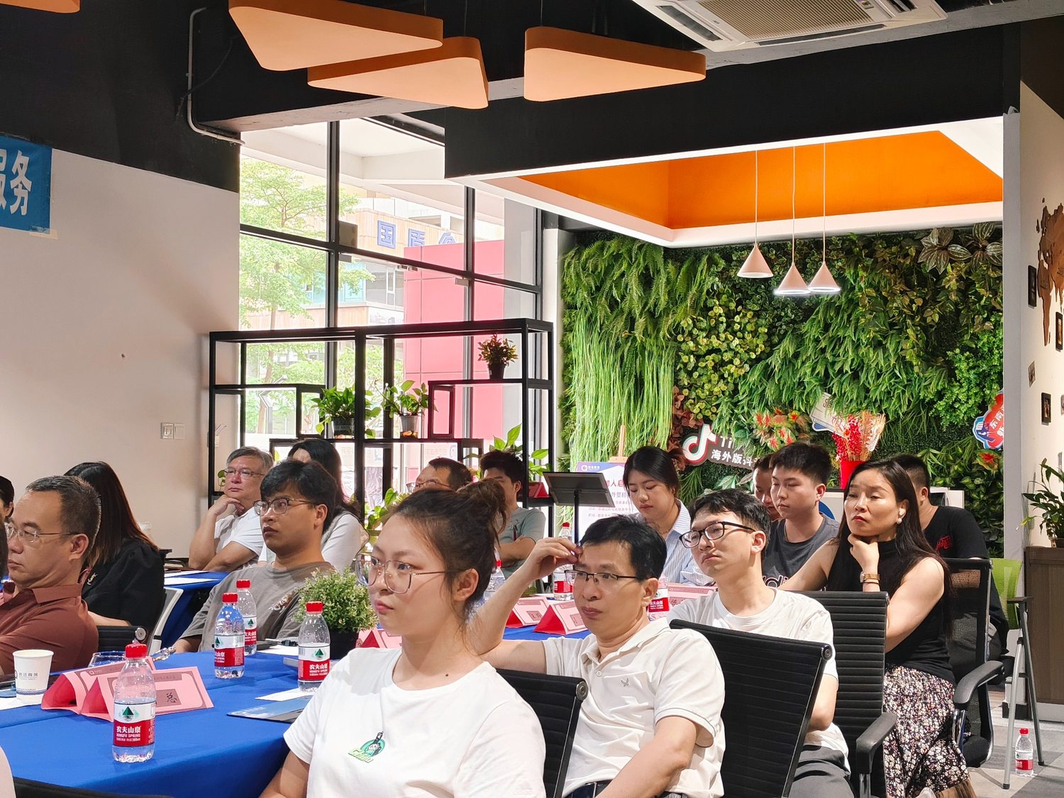 学员在课堂上举手发问，其他人继续听讲